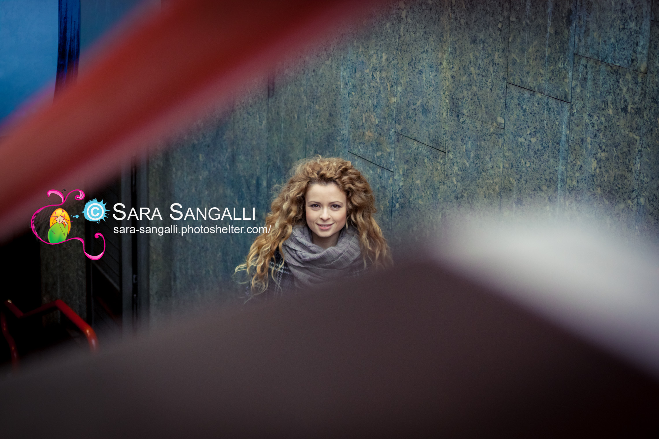 Young blonde woman looking at camera through the underground handrail