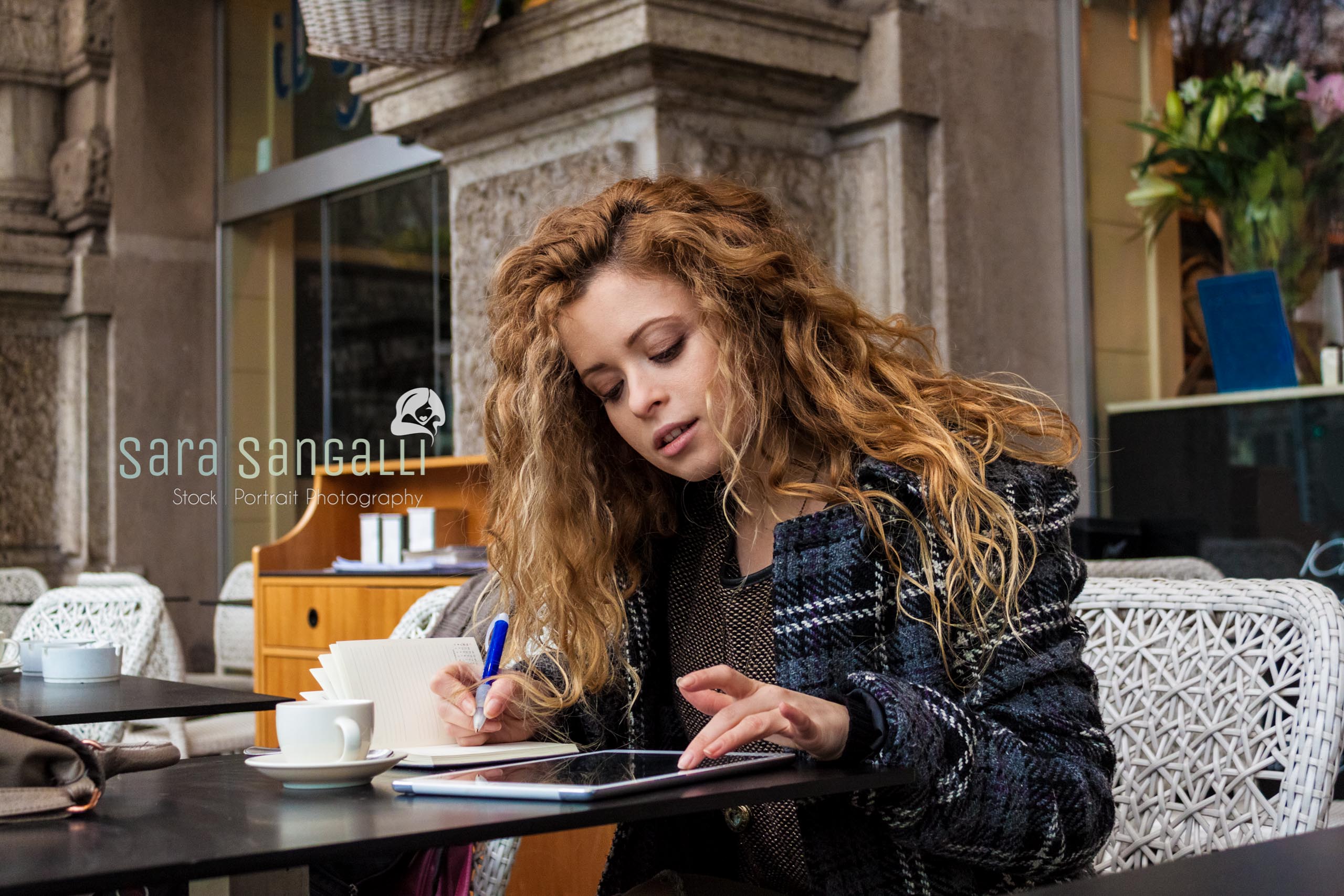 Taking notes on a tablet and writing on her calendar