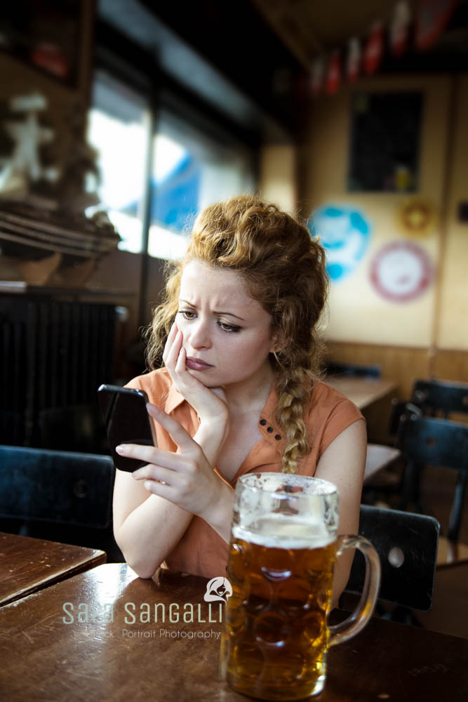 Young blonde looking at her phone with a sad face