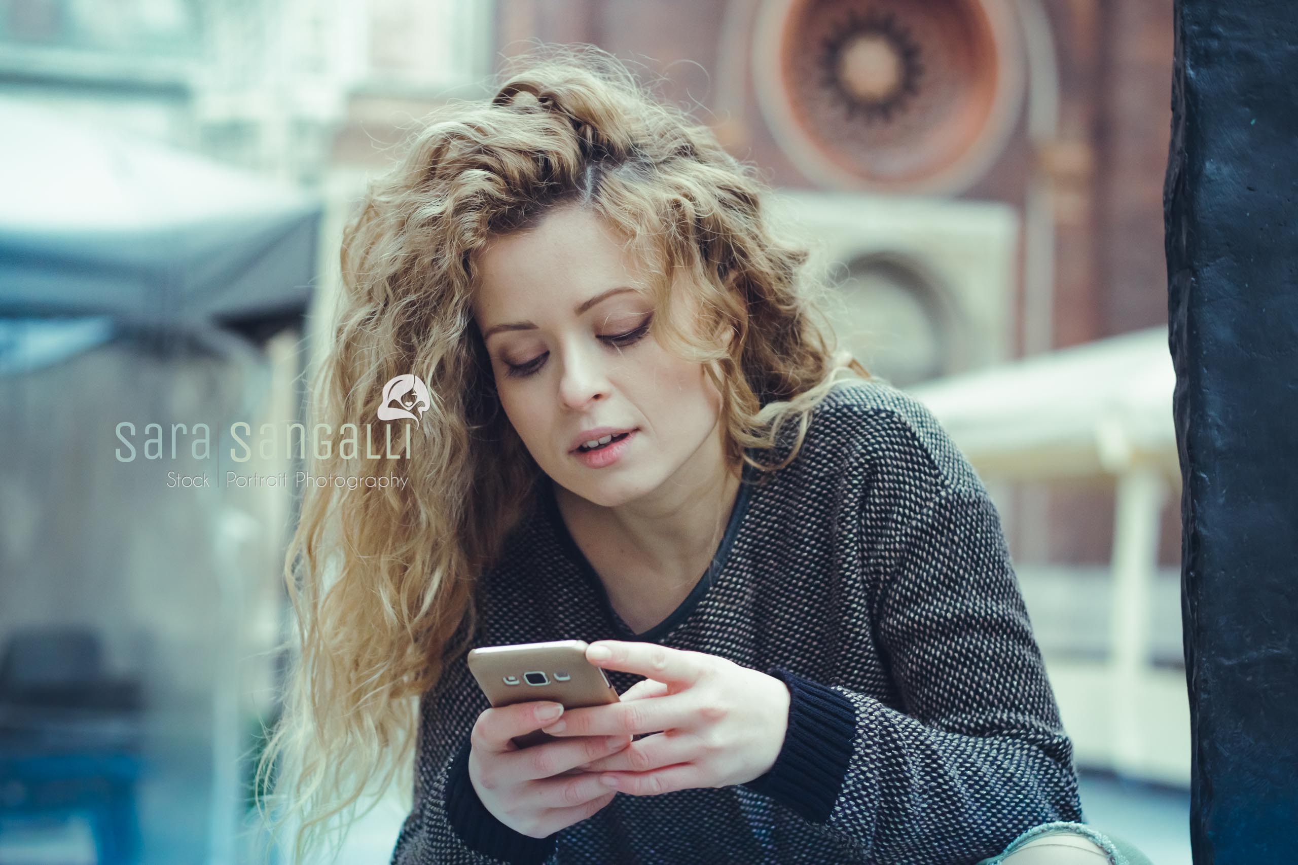 young blonde woman chatting on her smartphone