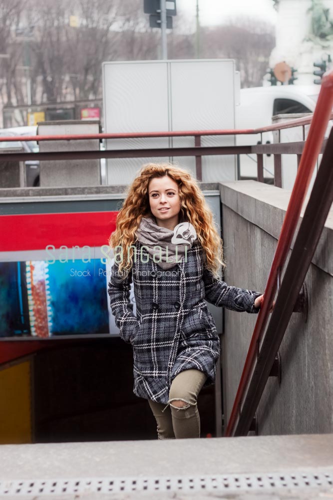 Young blonde woman walkin up the stairs of a underground station in Milan, Italy