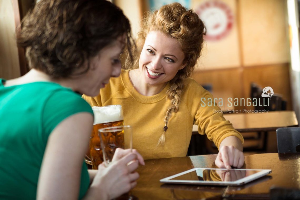 two friends getting toghether drinking beer and laughing