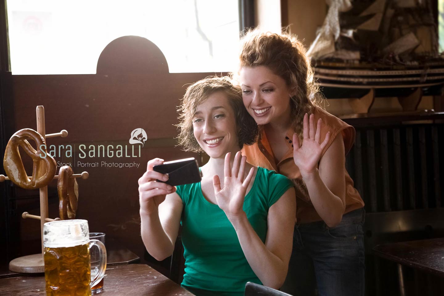 Two girlfriend waving at their smartphone